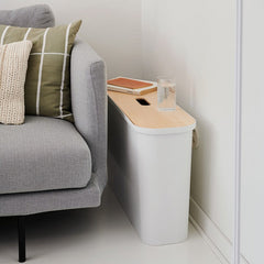 Gray sofa with a small wooden table next to it in a minimalistic living room.