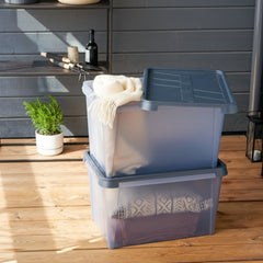 Two stacked storage bins with clothes on a wooden deck