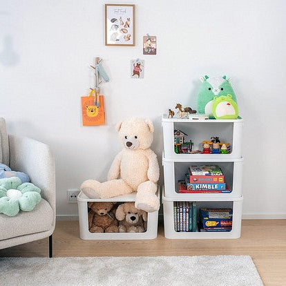 Children's room with a teddy bear on a chair, books on shelves, and toys around.