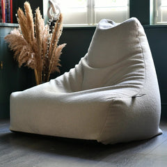 White bean bag chair in a room with green cabinets and decorative plants.