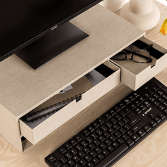 Beige desk with open drawer, black keyboard, and computer monitor on a wooden surface.
