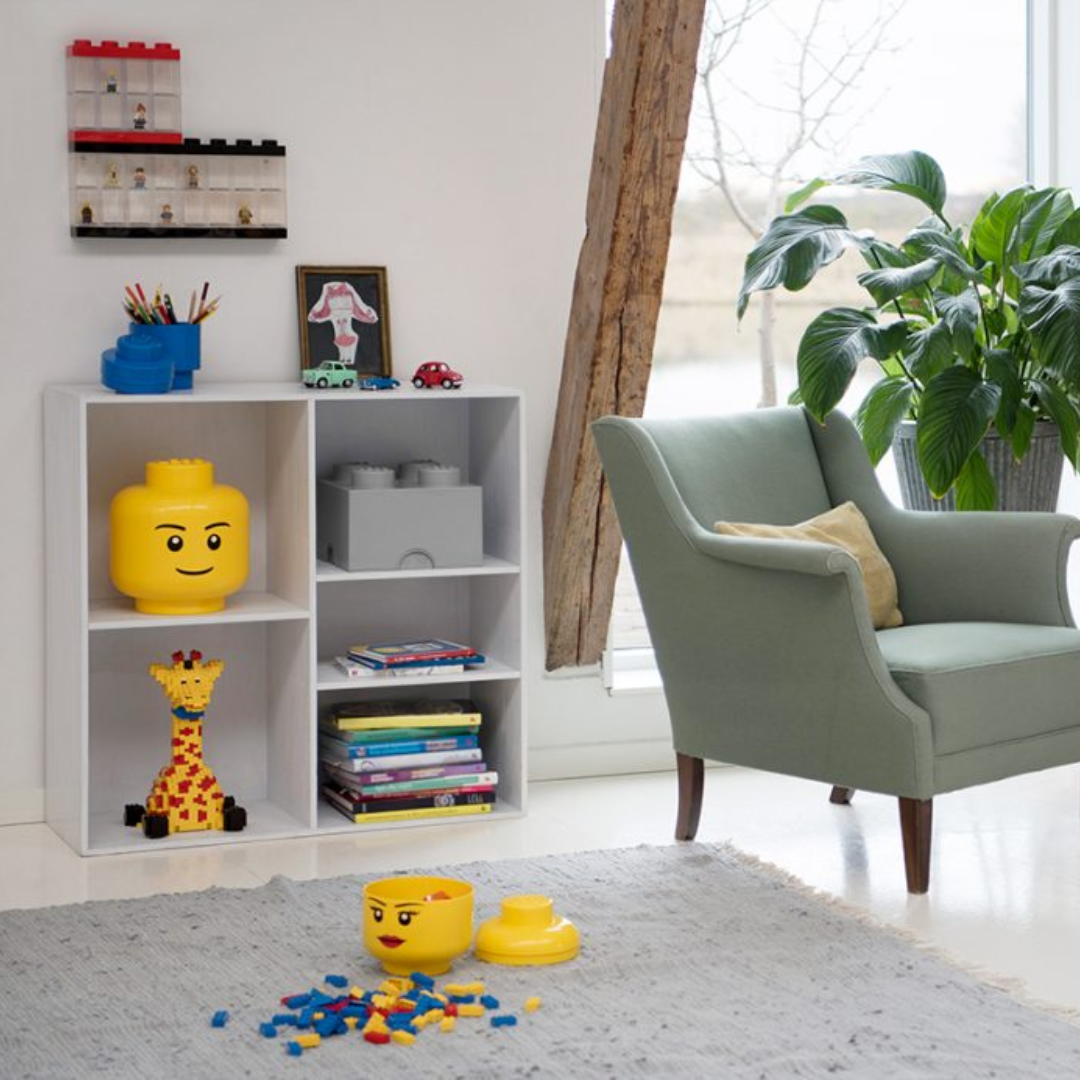 Children's room with toy storage unit, chair, and toys on a rug.
