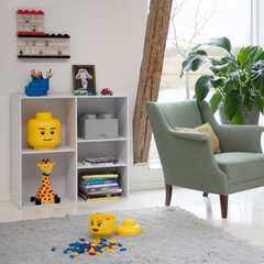 Children's room with toy storage unit, chair, and toys on a rug.