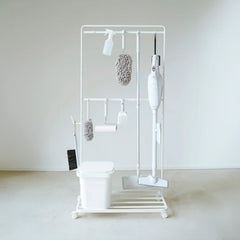 White cleaning tool organizer with various brushes and sponges on a white background