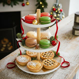 Three-tiered white serving tray with pastries on a wooden surface