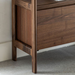 Close-up of a wooden cabinet with a focus on the corner and base.